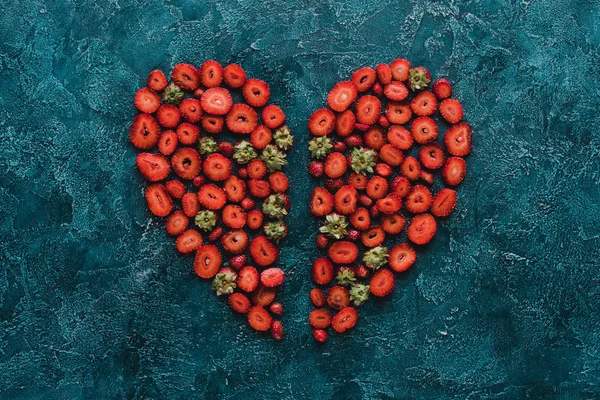 Top View Halved Heart Sign Made Strawberries Blue Concrete Surface — стоковое фото