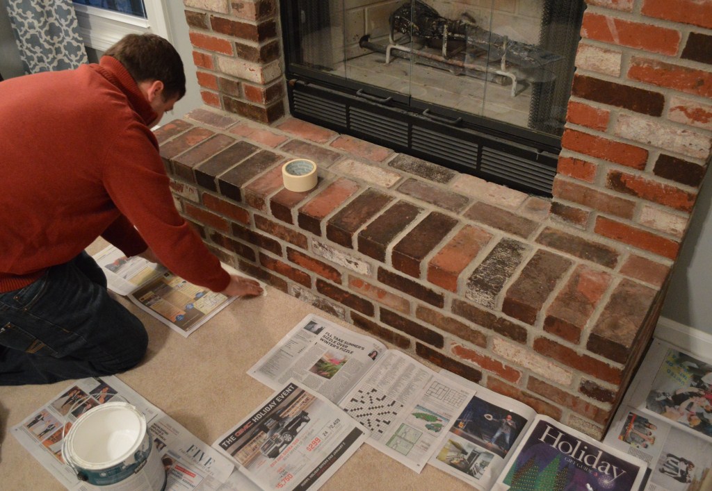 protecting floor with newspapers before fireplace whitewash